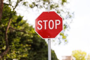 Red stop sign with foliage behind