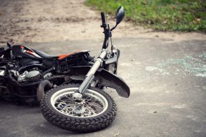 Broken motorcycle on the road after traffic incident