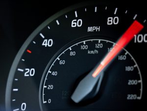 Close-up showing the needle on a car's speedometer moving towards 100 miles per hour. reckless driving. speeding. driving over the speed limit.