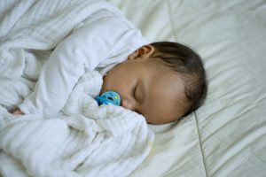 Daughter is sleeping alone close to her mother in bedroom.