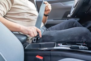 Man Fastening His Seatbelt In Car. Putting On Safety Seatbelt.