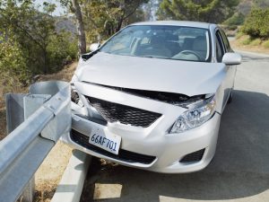 Car wrecked on road guardrail